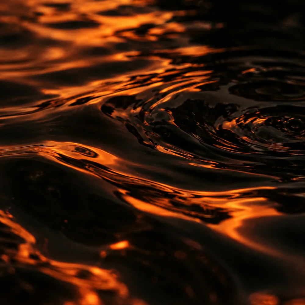 Ondulations noires traversées de lumière orange